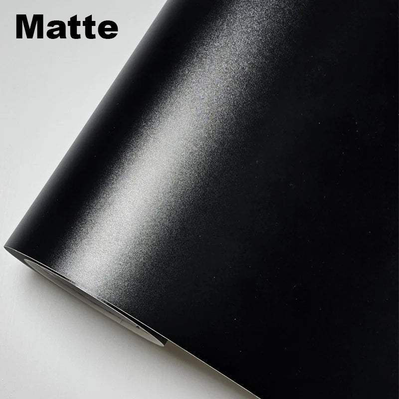 Matte black vinyl wrap sheet on a light gray background